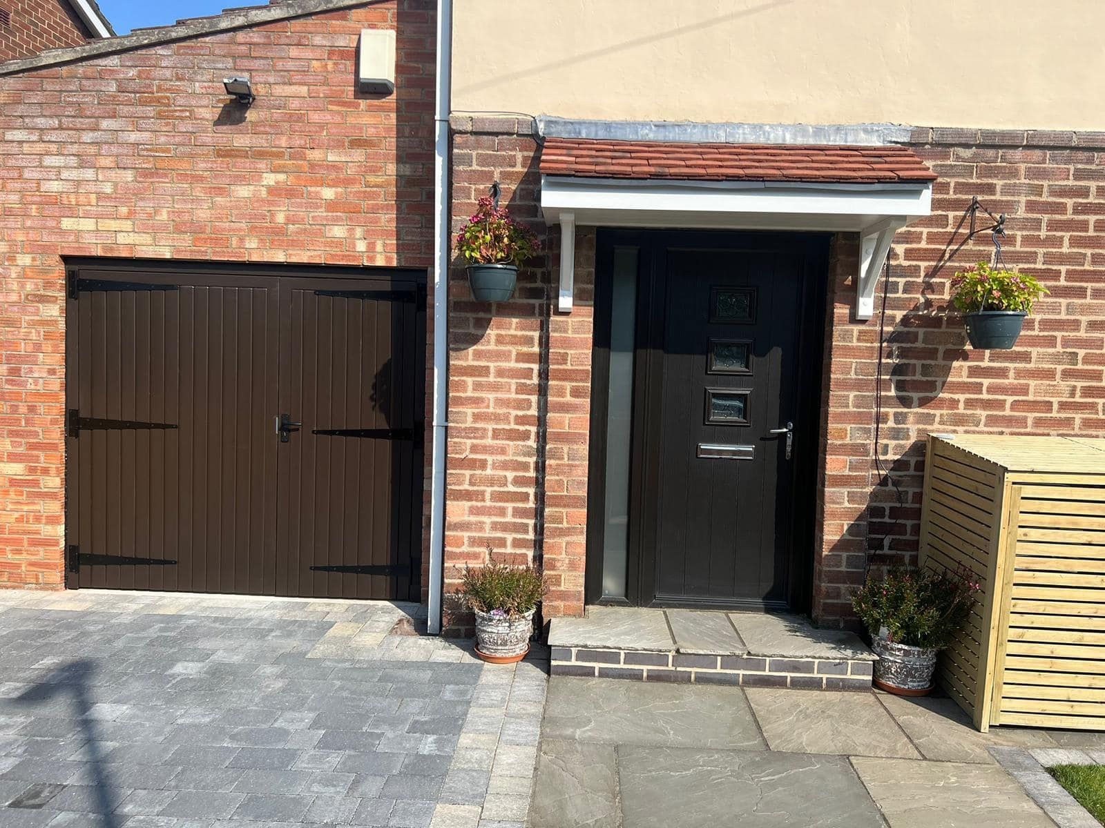 A brick house with a black door and a black garage door.