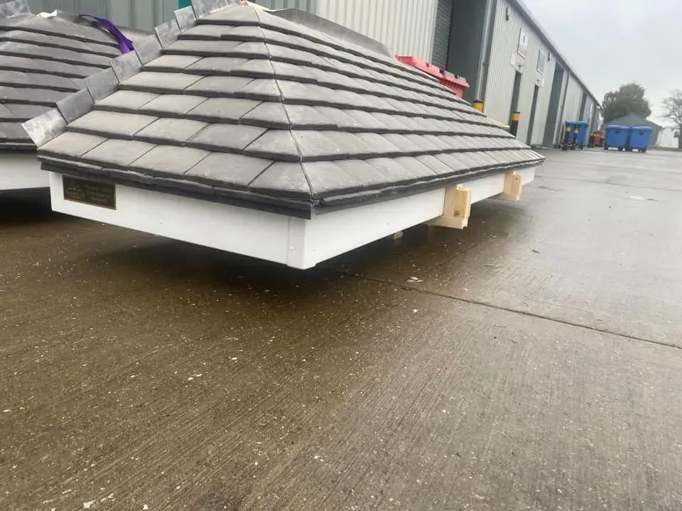 A roof is sitting on the ground in front of a building.