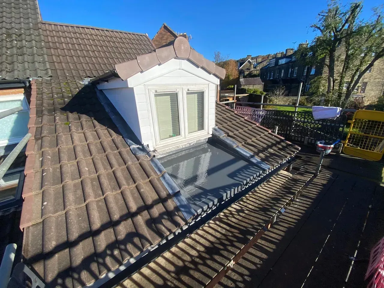 There is a window on the roof of a house.