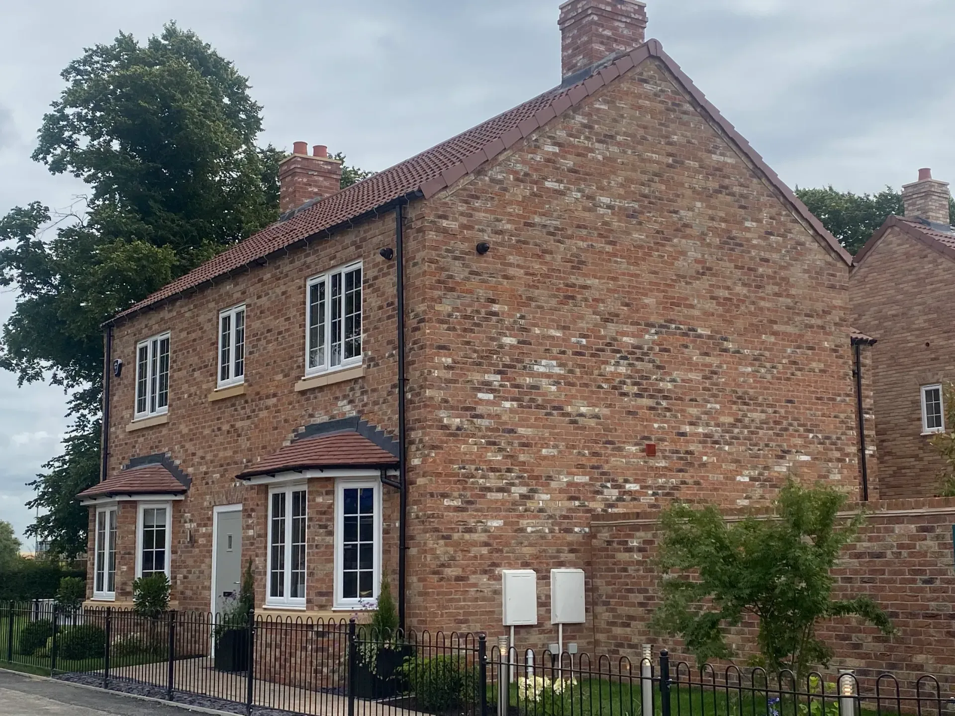 A large brick house with a fence in front of it