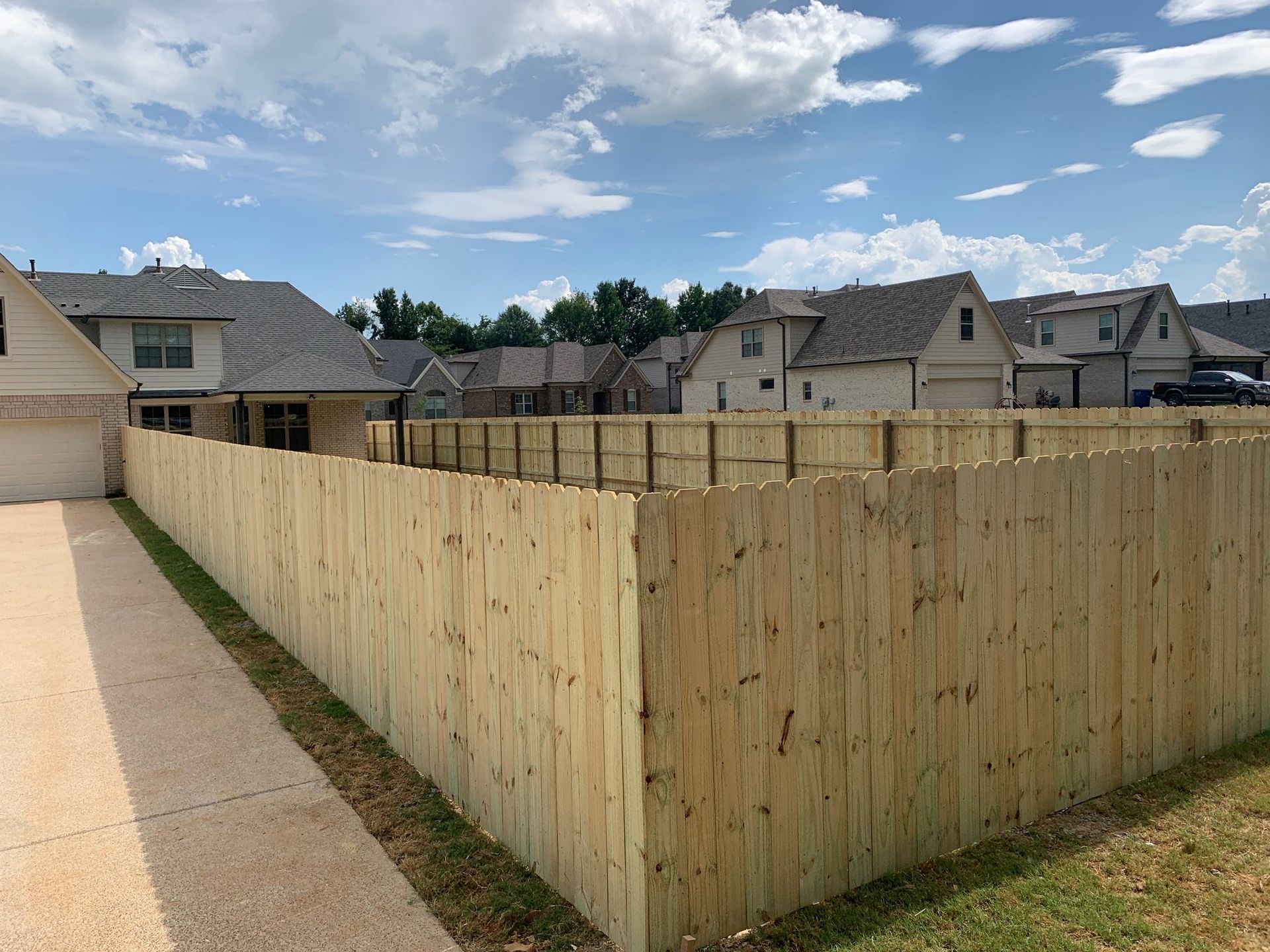 A wooden fence is surrounded by houses in a residential area.