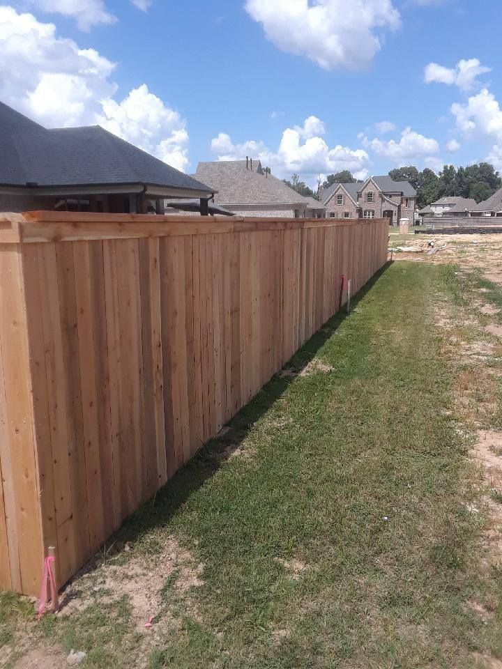 A wooden fence is sitting in the middle of a lush green field.