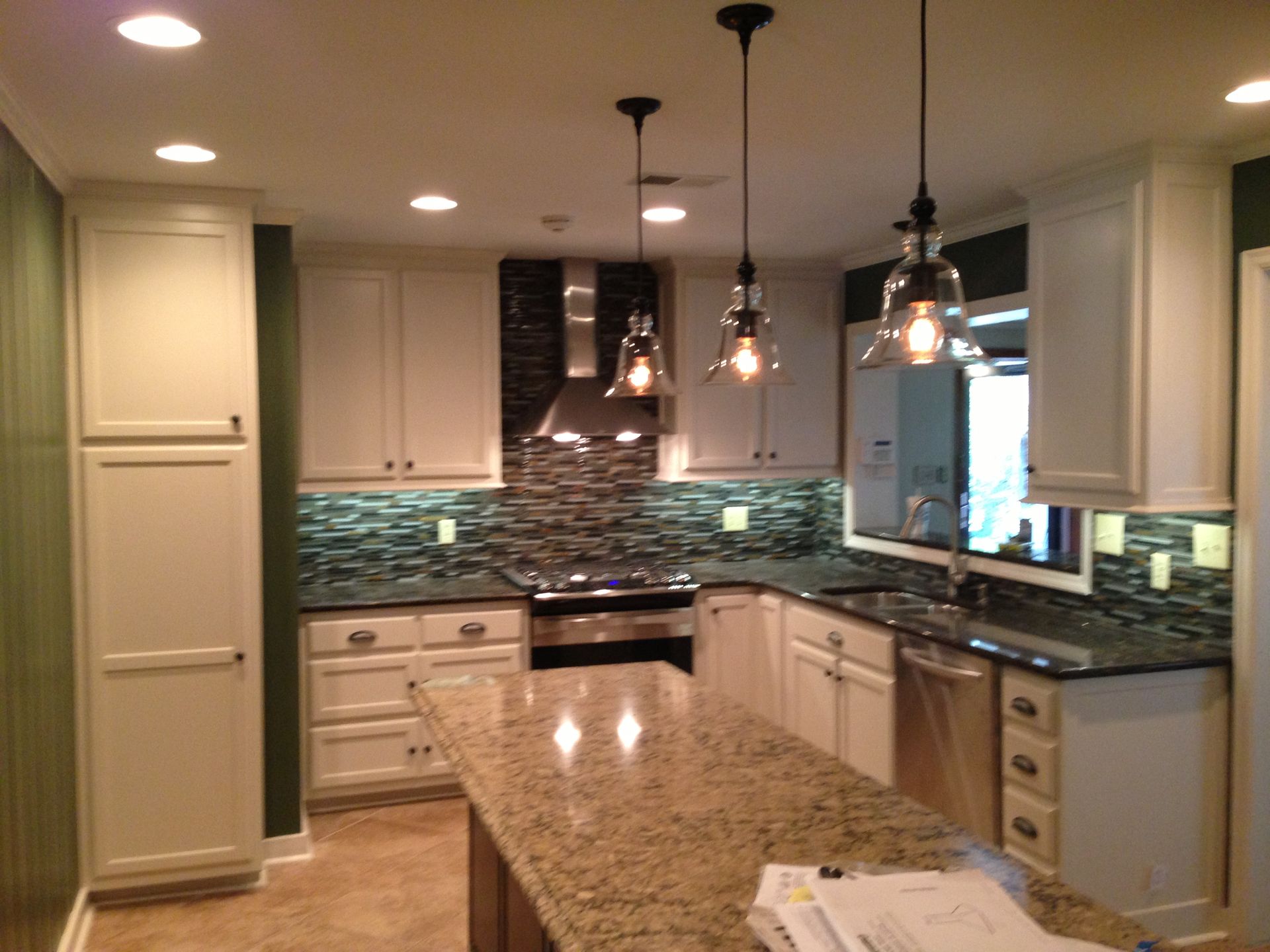 A kitchen with granite counter tops and white cabinets