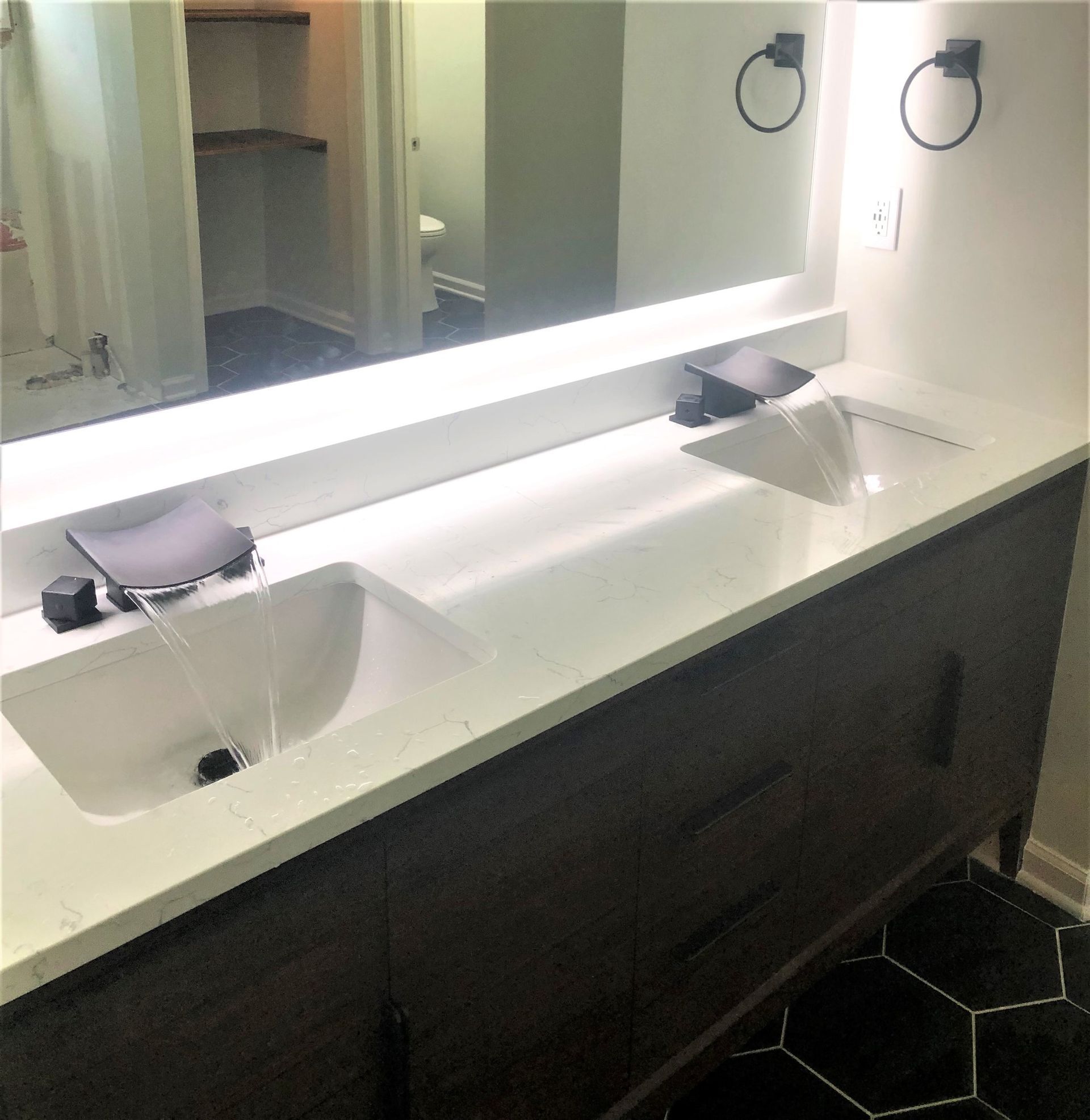 A bathroom with two sinks and a large mirror.