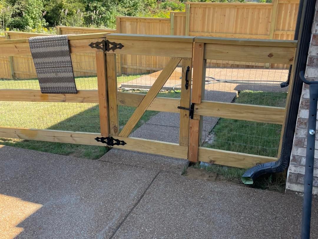 A wooden fence with a gate in the backyard of a house.