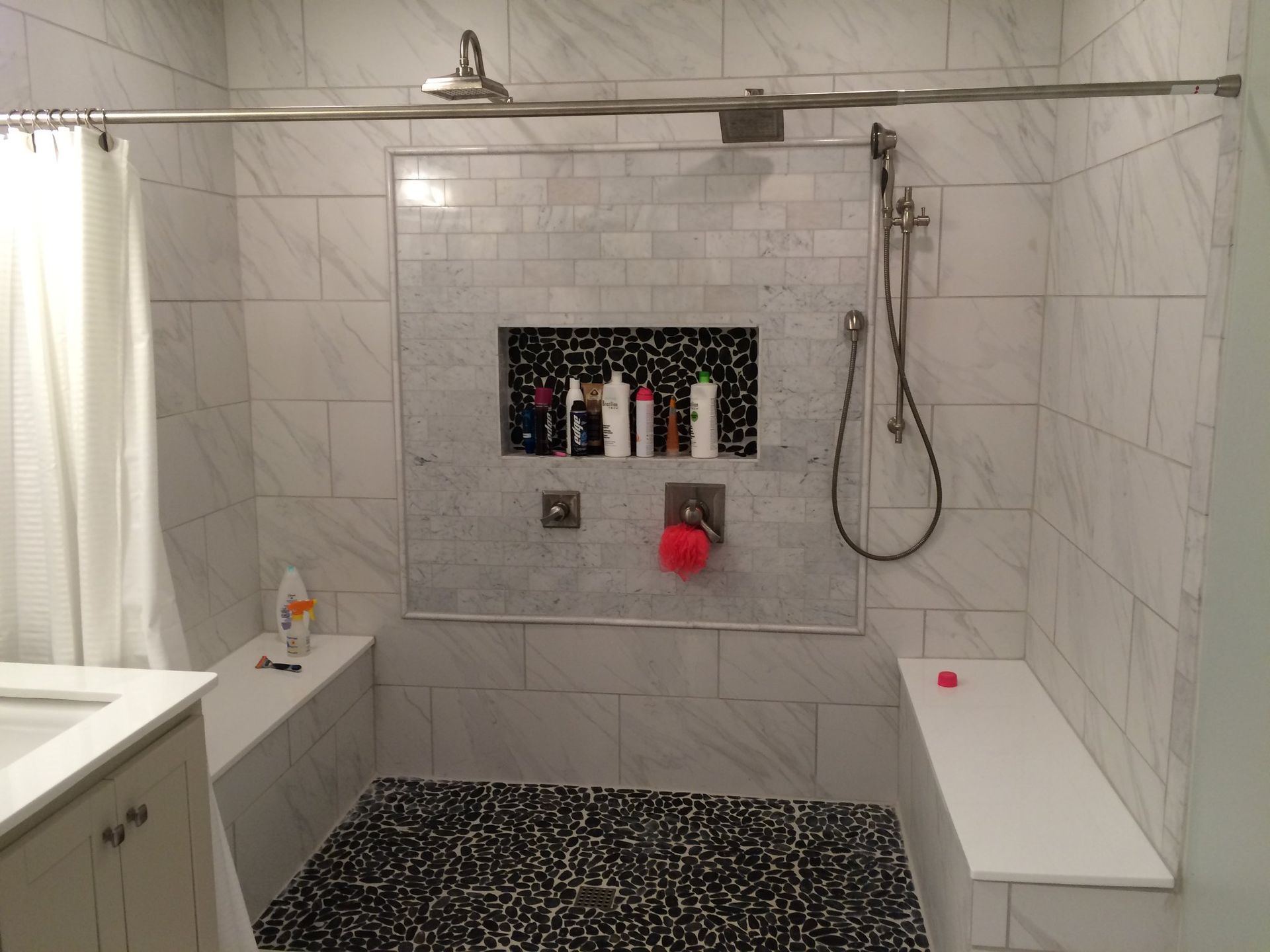 A bathroom with a walk in shower and a bench