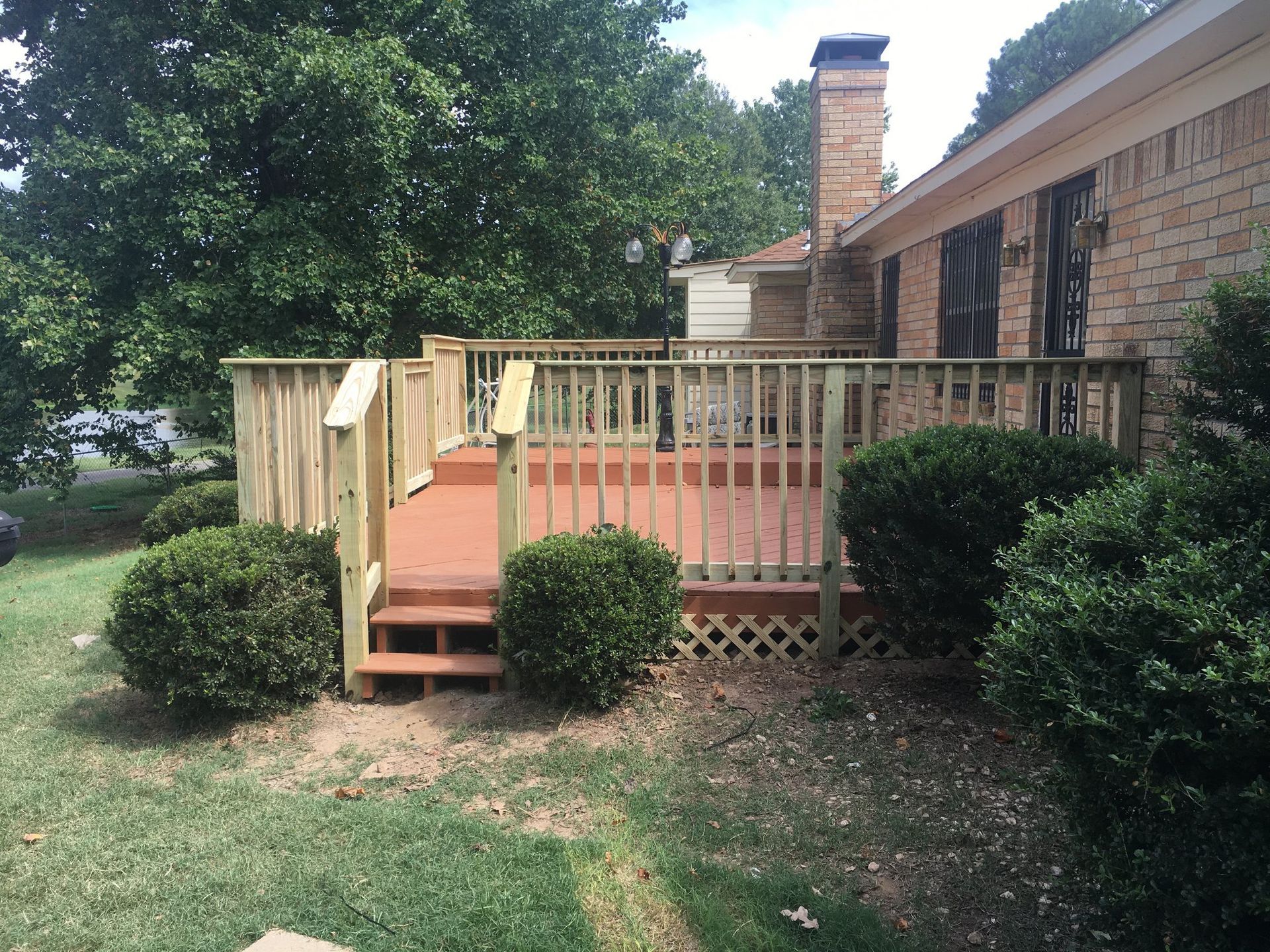 A brick house with a wooden deck in front of it