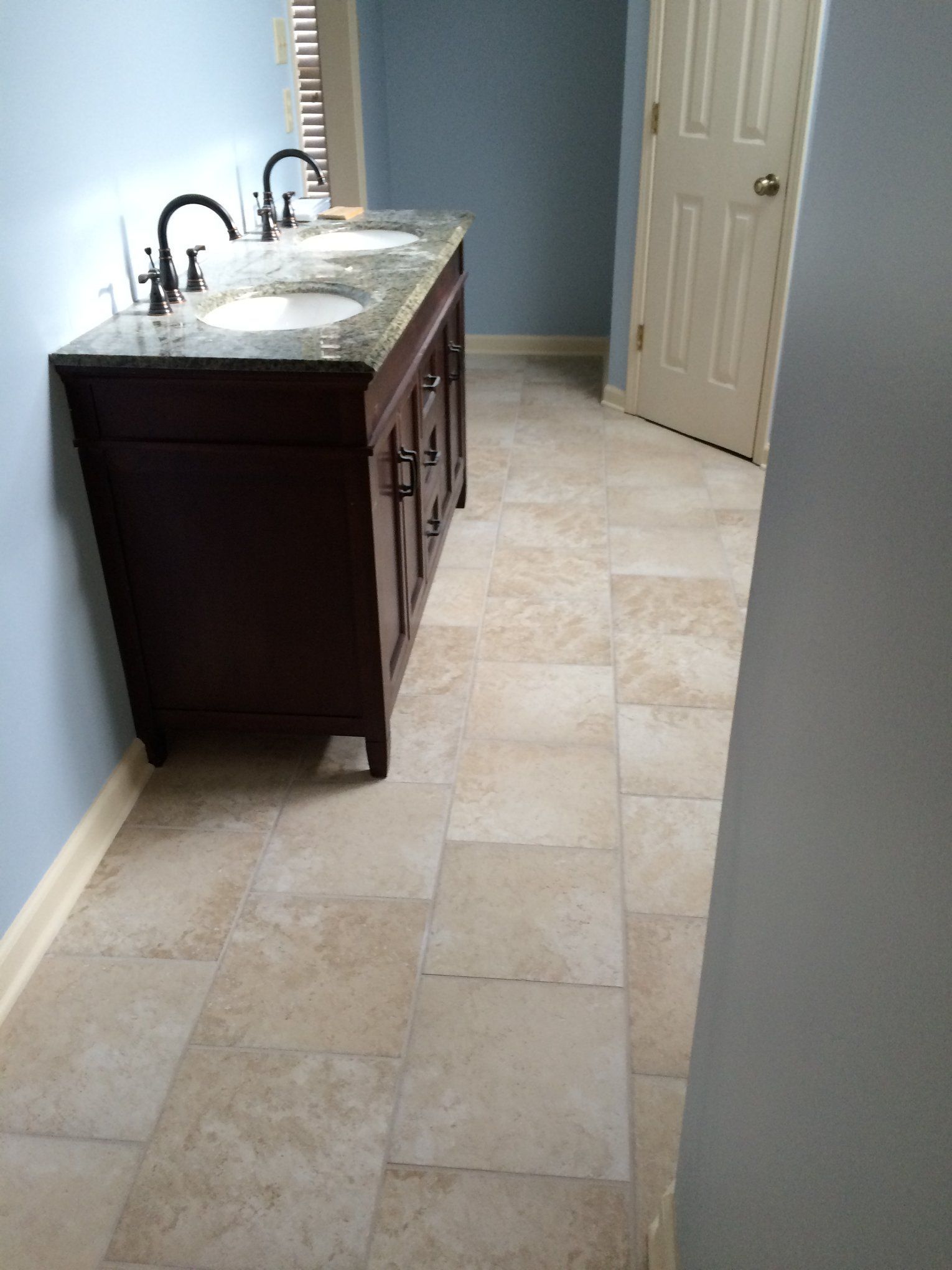 A bathroom with two sinks and a tiled floor
