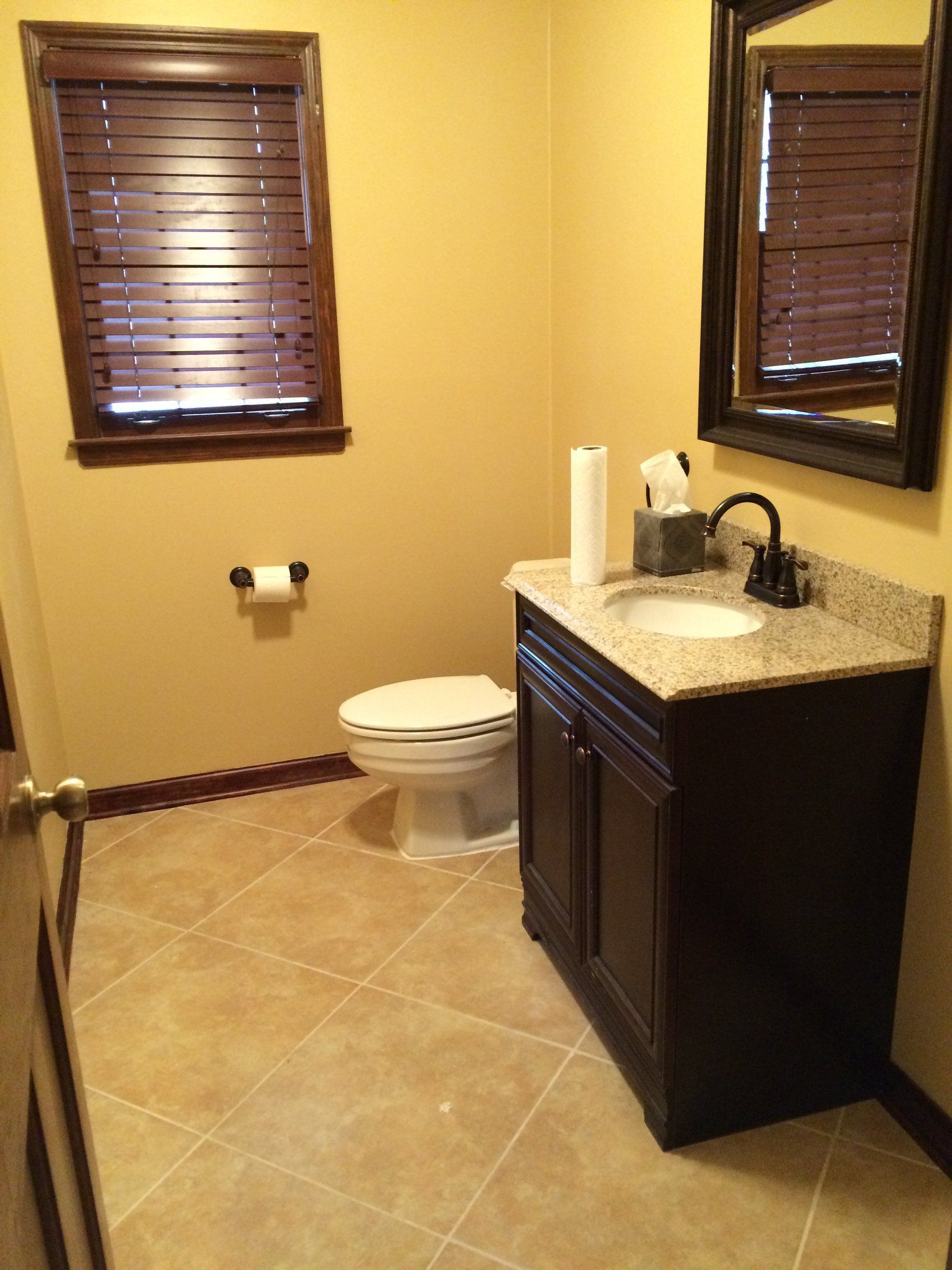 A bathroom with a toilet a sink and a mirror