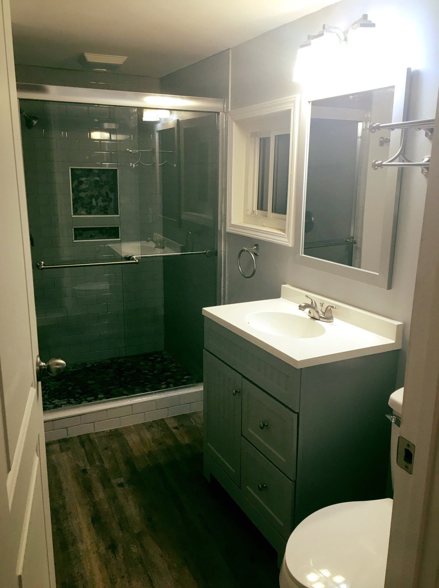 A bathroom with a sink , toilet and shower.