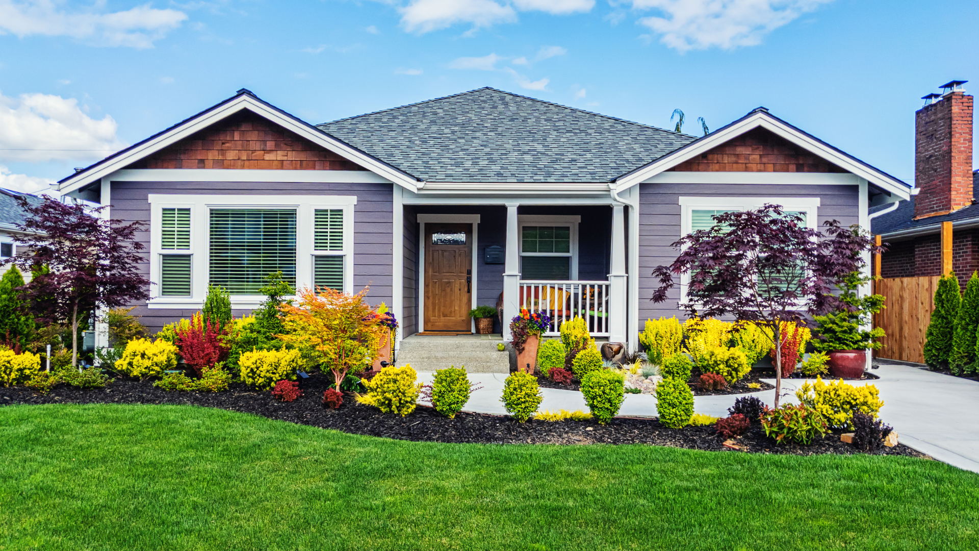 A purple house with a large lawn in front of it.