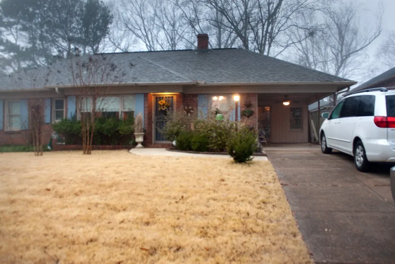 A white van is parked in front of a house.