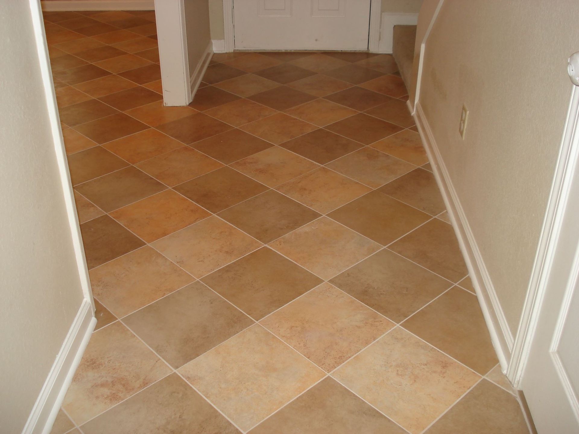 A hallway with a checkered tile floor and white trim