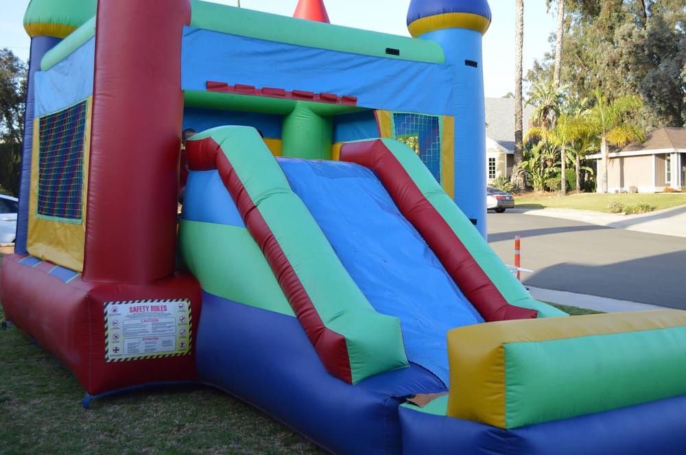 A colorful bouncy house with a slide and stairs