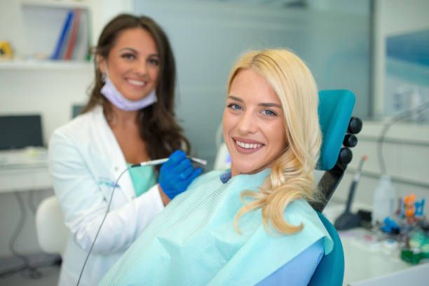 Picture of a doctor and her patient receiving dental whitening treatment at the clinic.