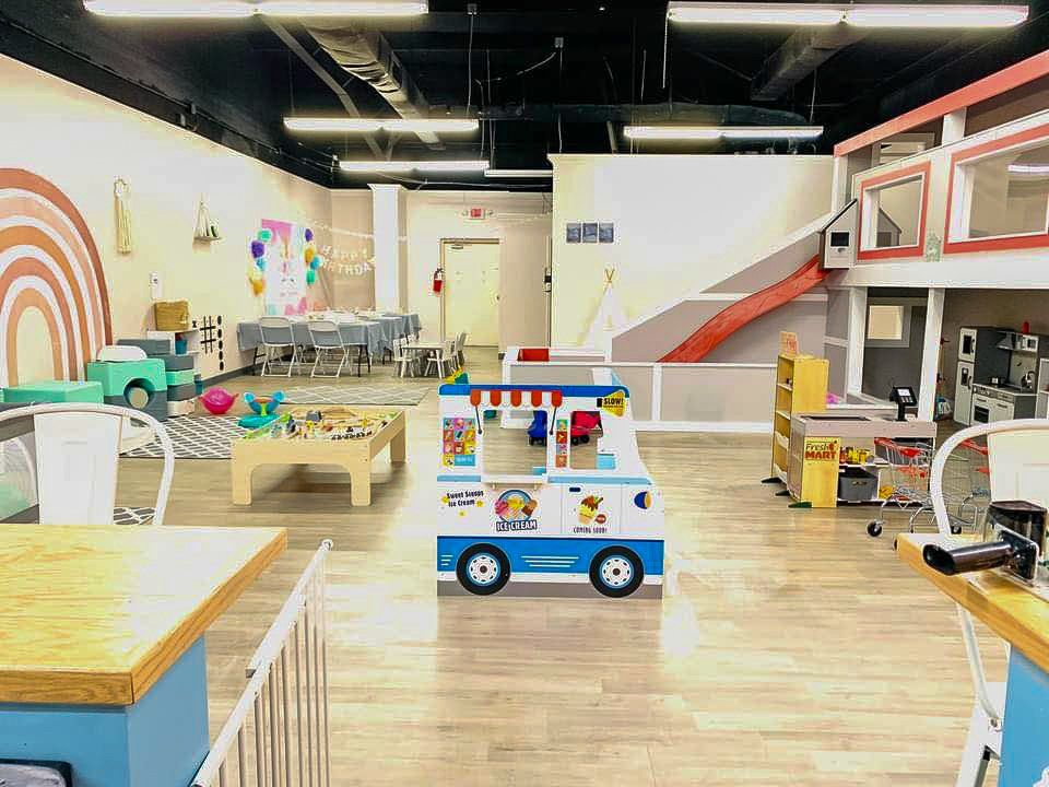 A large room filled with lots of toys and tables.