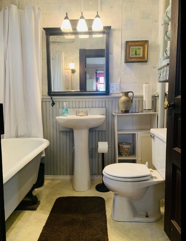 A bathroom with a toilet a sink and a bathtub