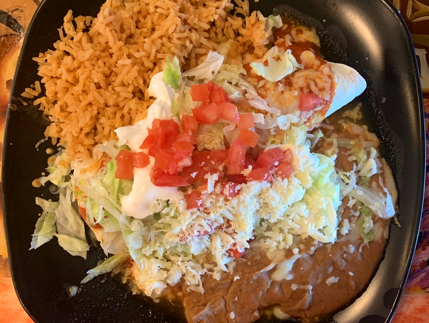A close up of a plate of food with rice and beans on a table.