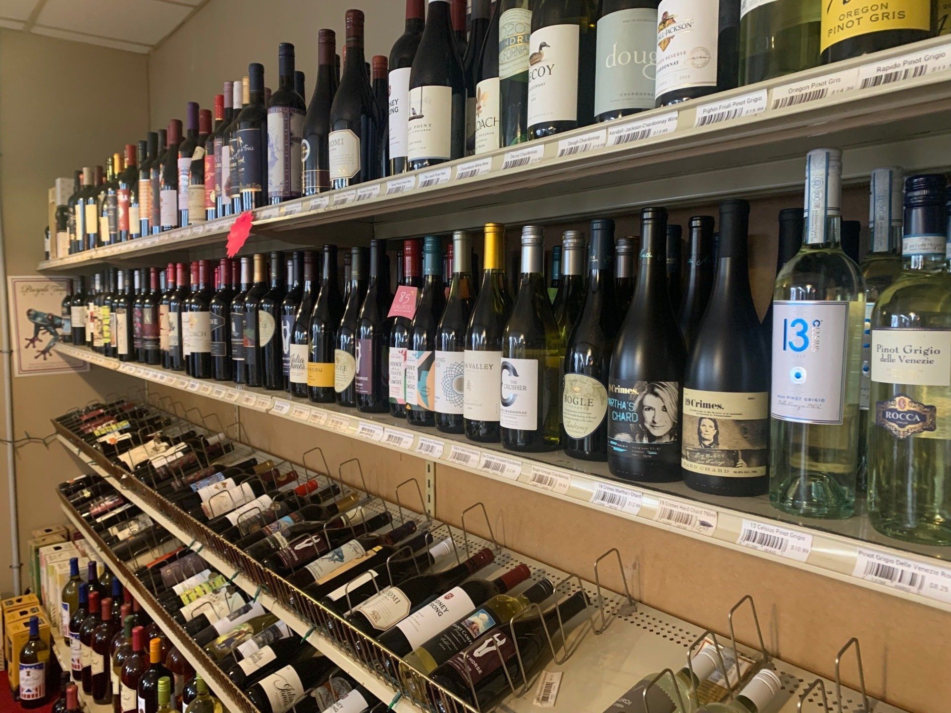 A shelf filled with lots of bottles of wine.