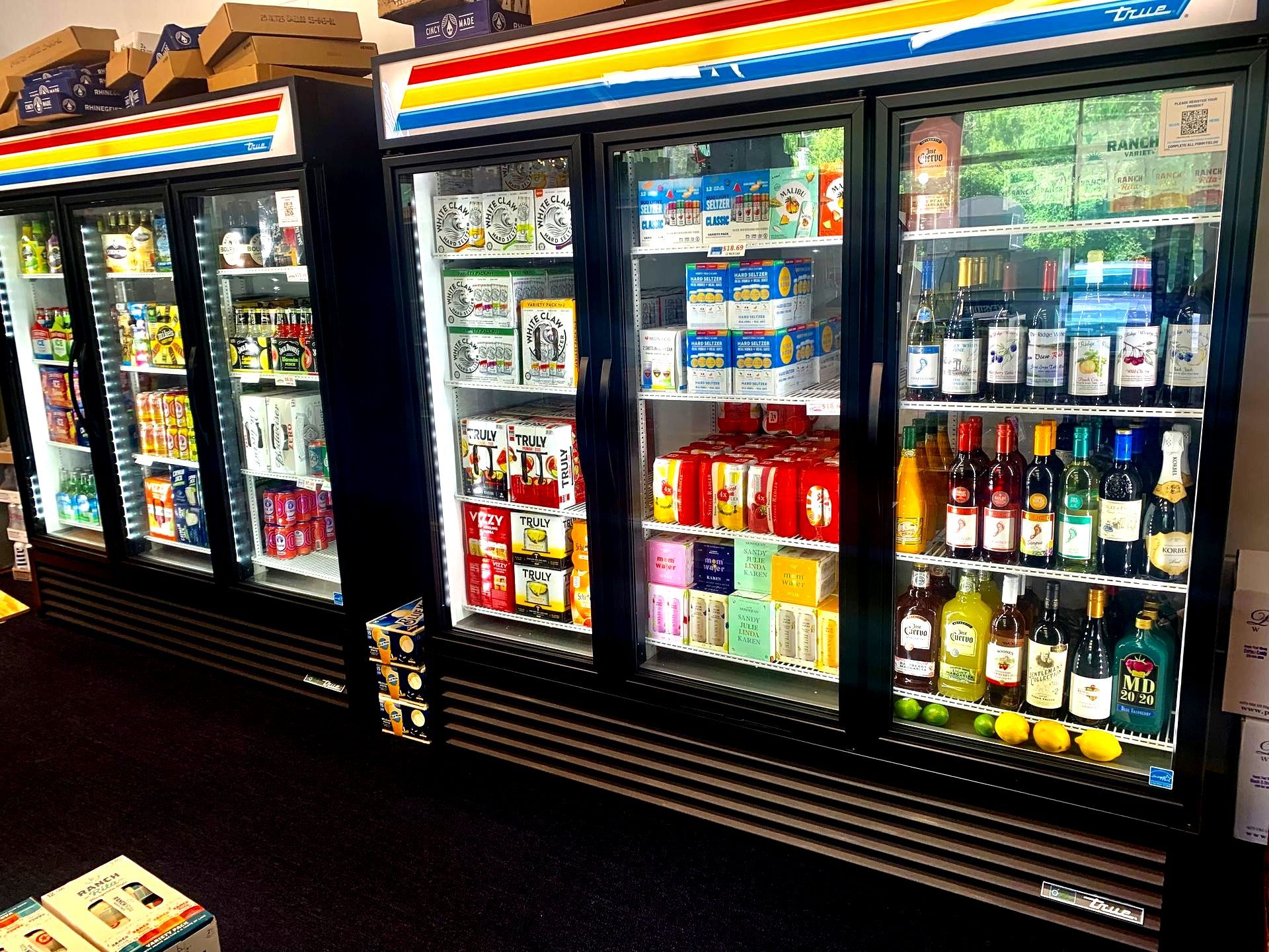 A row of refrigerators filled with bottles and cans of alcohol.