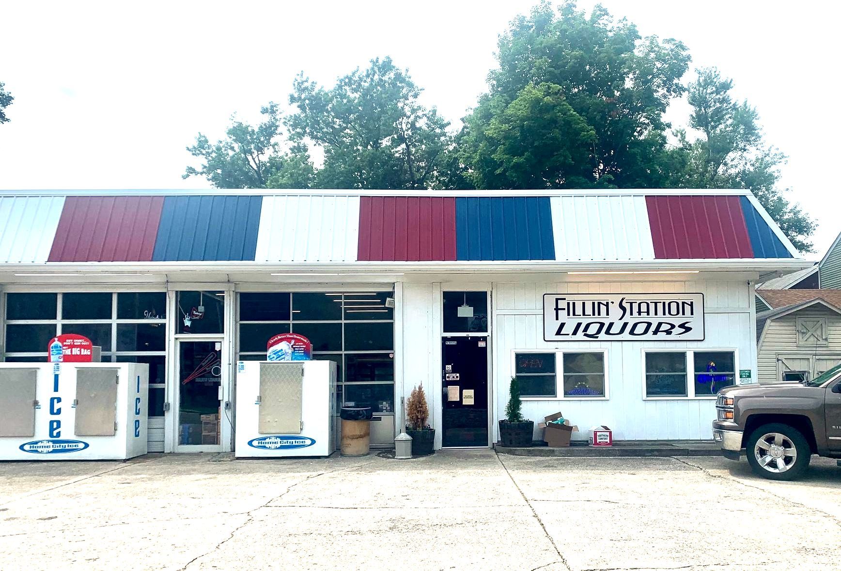 A fluid station liquor store with a red white and blue awning
