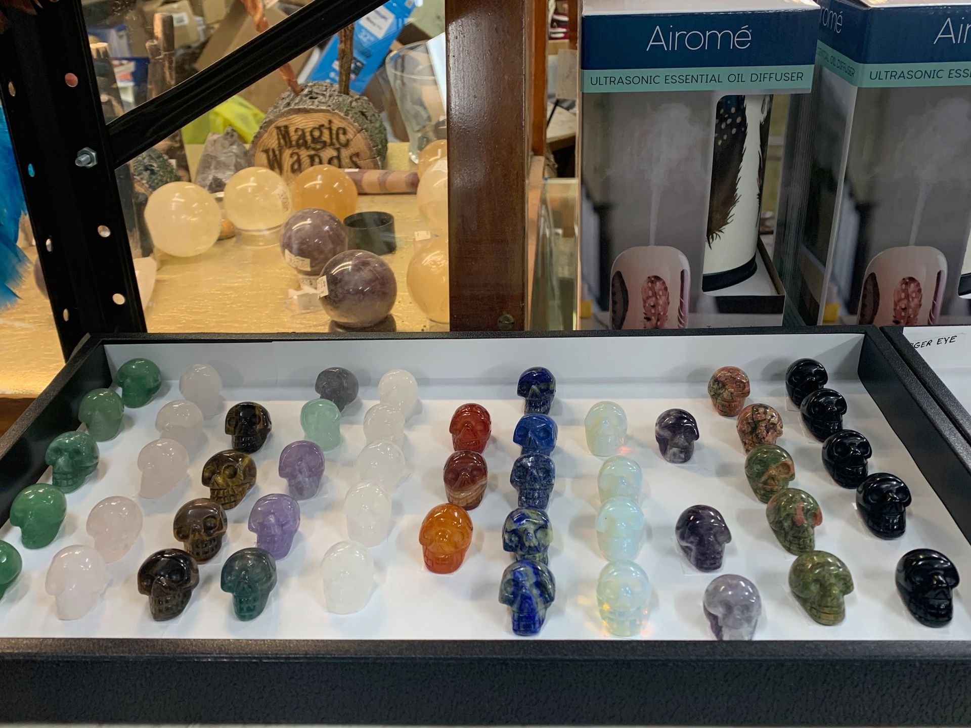 A variety of crystal skulls are on display in a store.