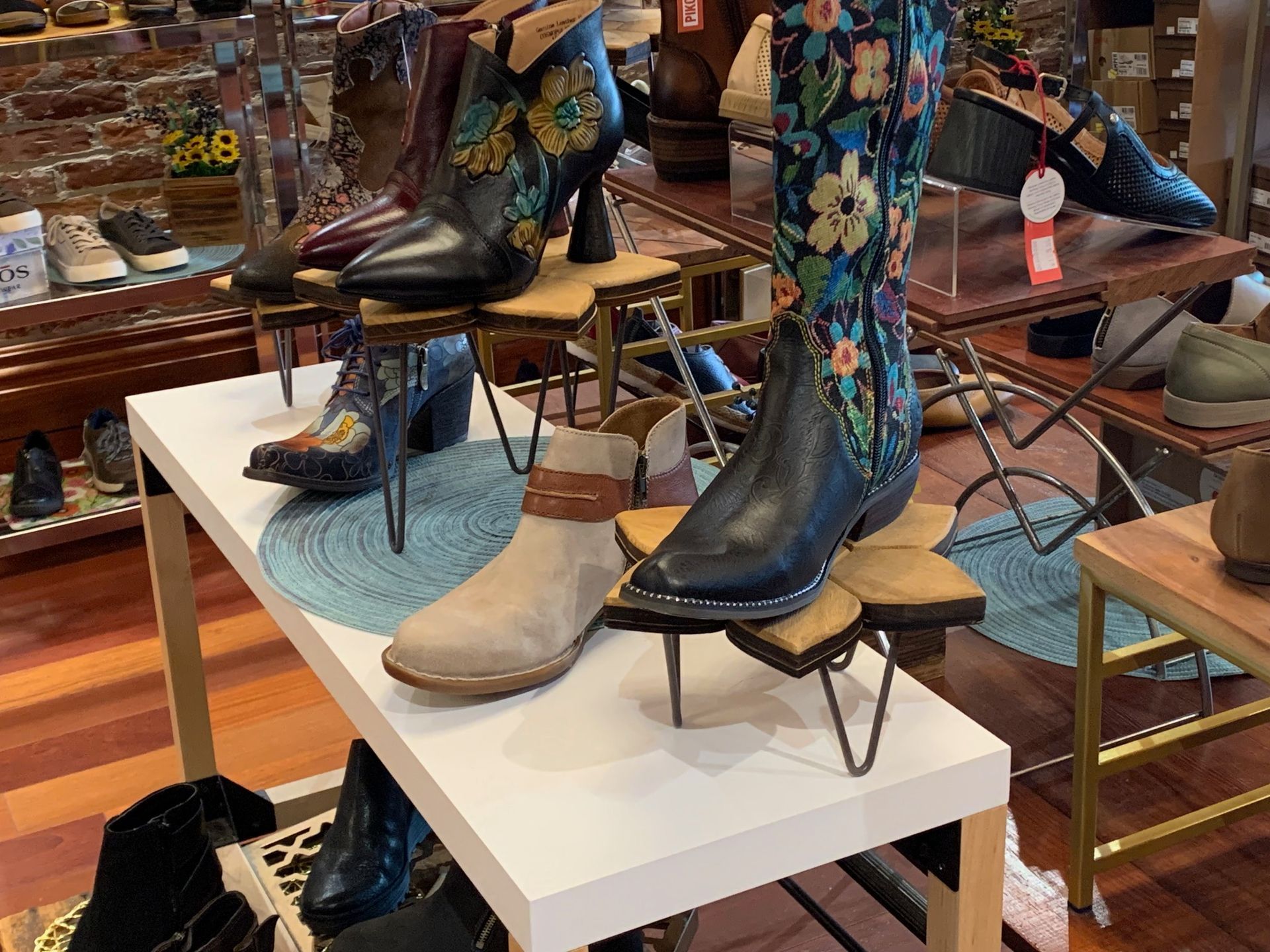 A display of cowboy boots on a table in a shoe store.