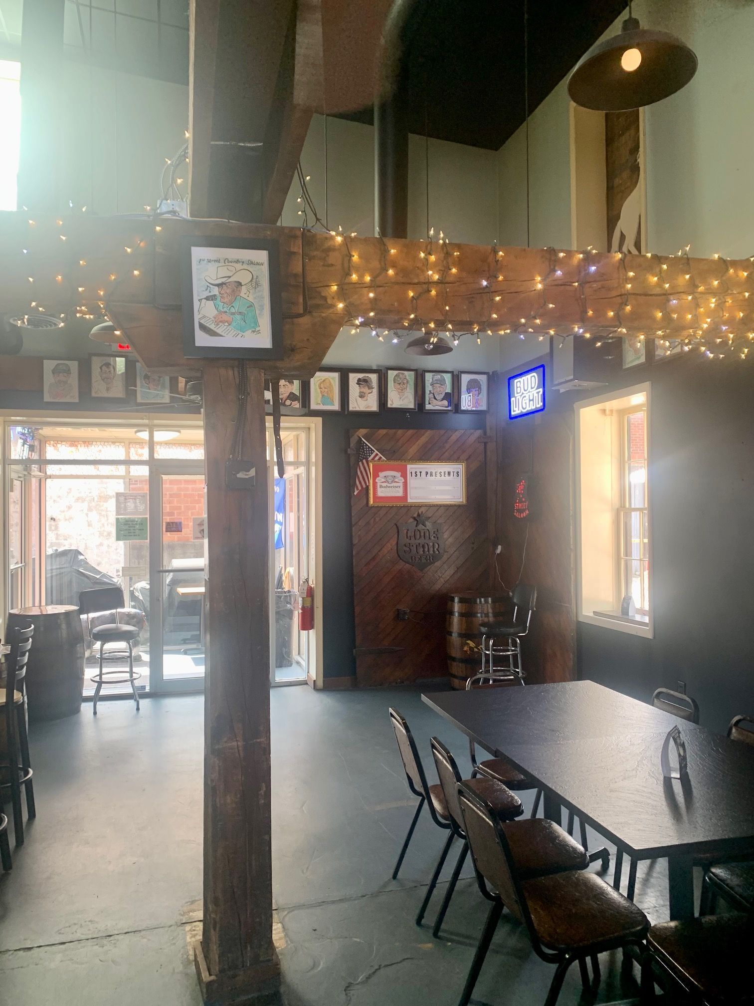 A restaurant with tables and chairs and a wooden pole in the middle of the room.