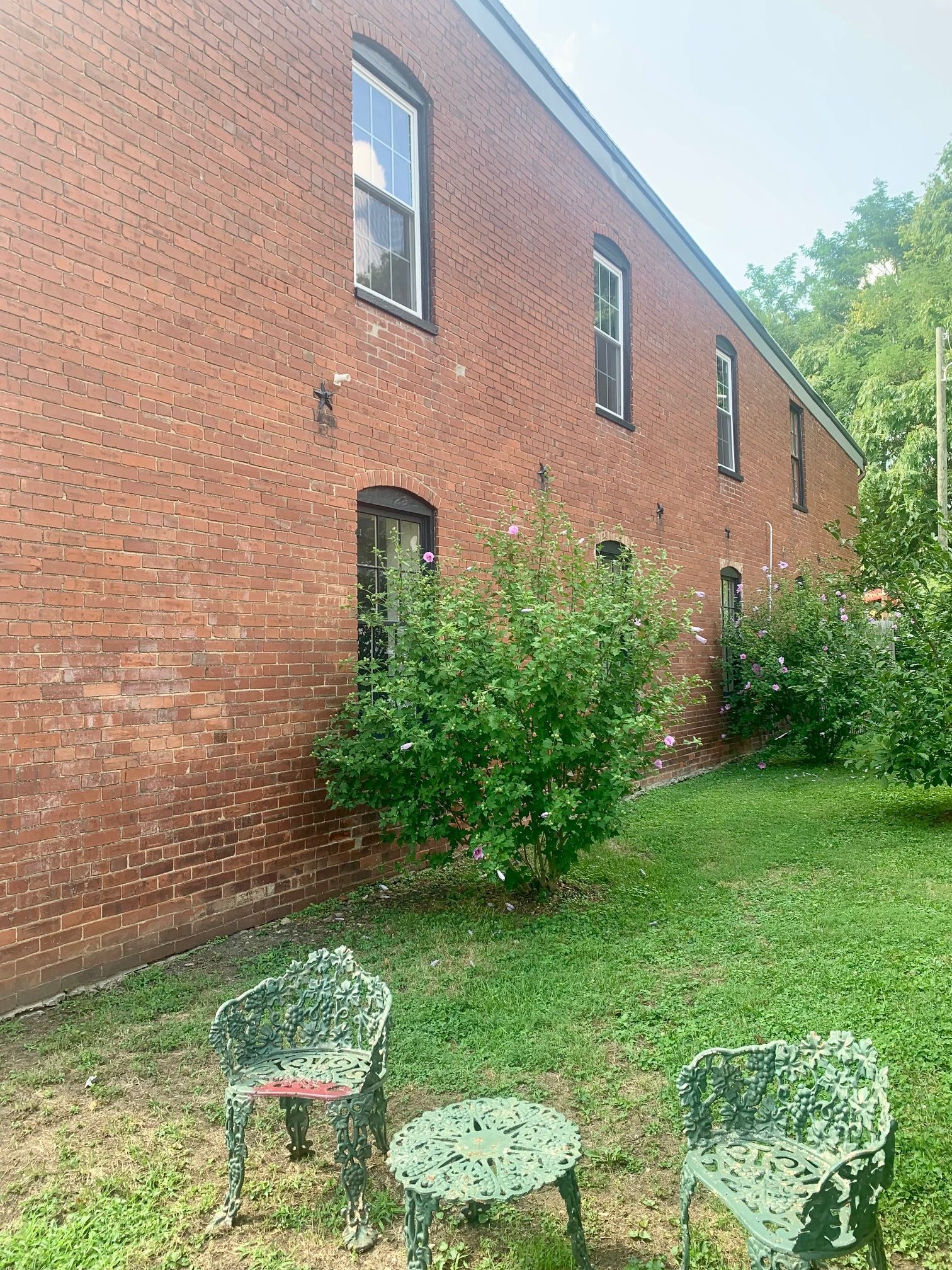 A brick building with two chairs and a table in front of it.