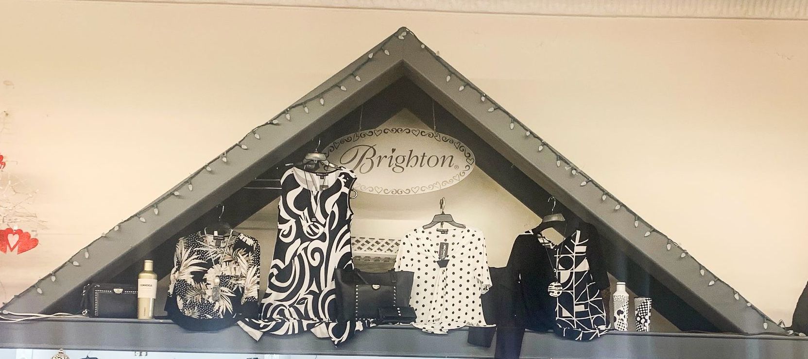 A display of clothes in a store with a triangle shaped shelf.