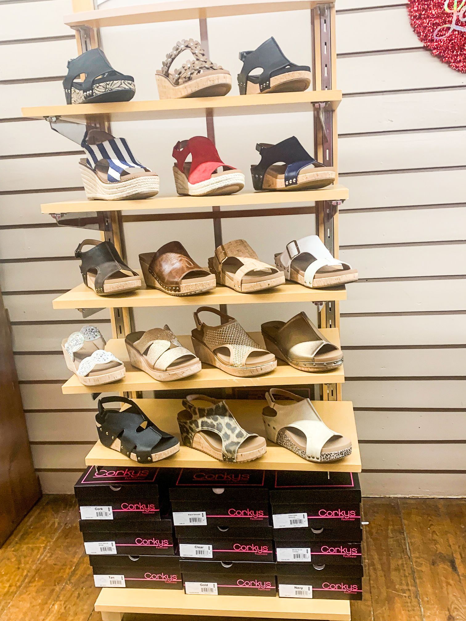 A display of sandals on a wooden shelf in a store.