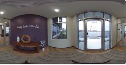 A 360 degree view of a room with a purple wall and a door.