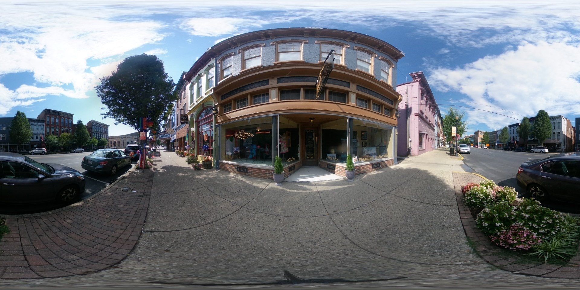 A 360 degree view of a building with cars parked in front of it