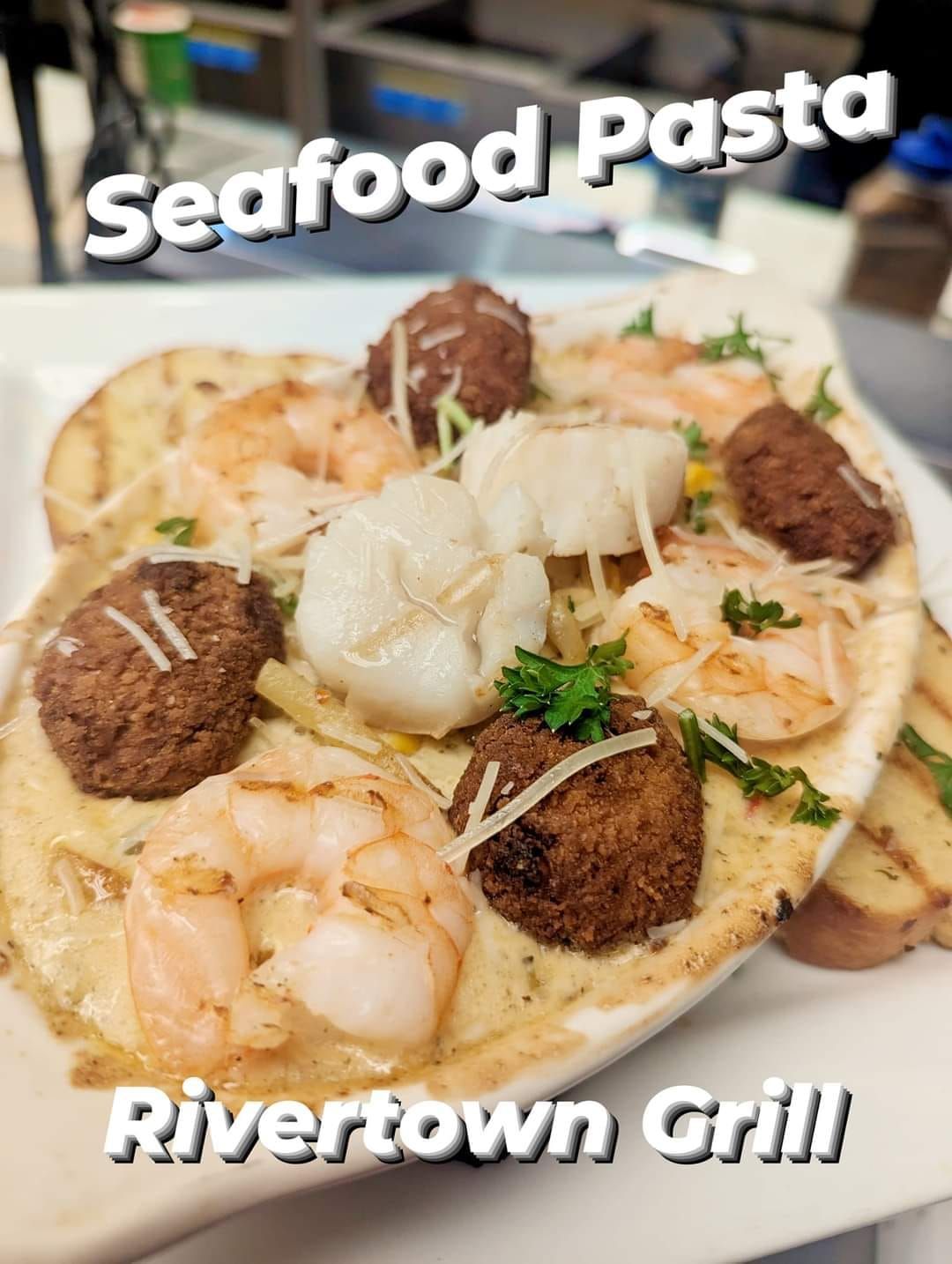 A white plate topped with seafood pasta from rivertown grill.