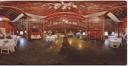 A 360 degree view of a large barn filled with tables and chairs.