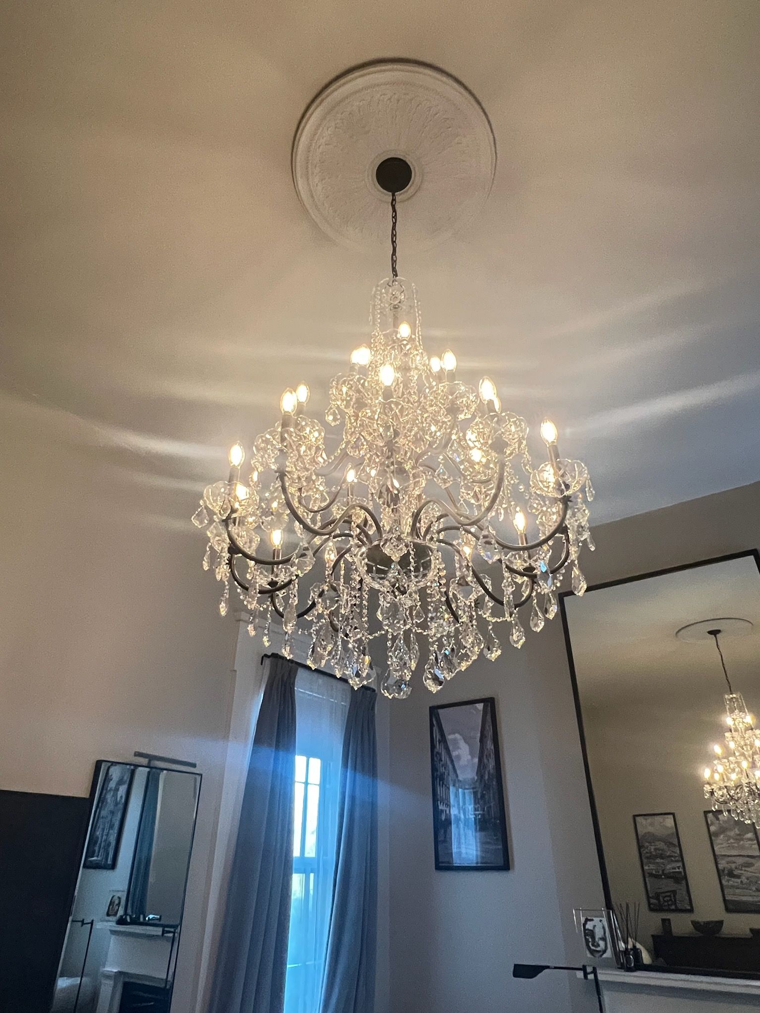A large chandelier is hanging from the ceiling in a bedroom.