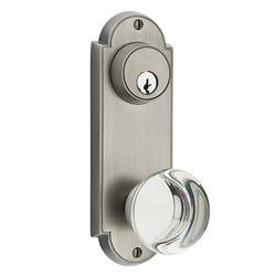A stainless steel door knob with a clear glass knob on a white background.