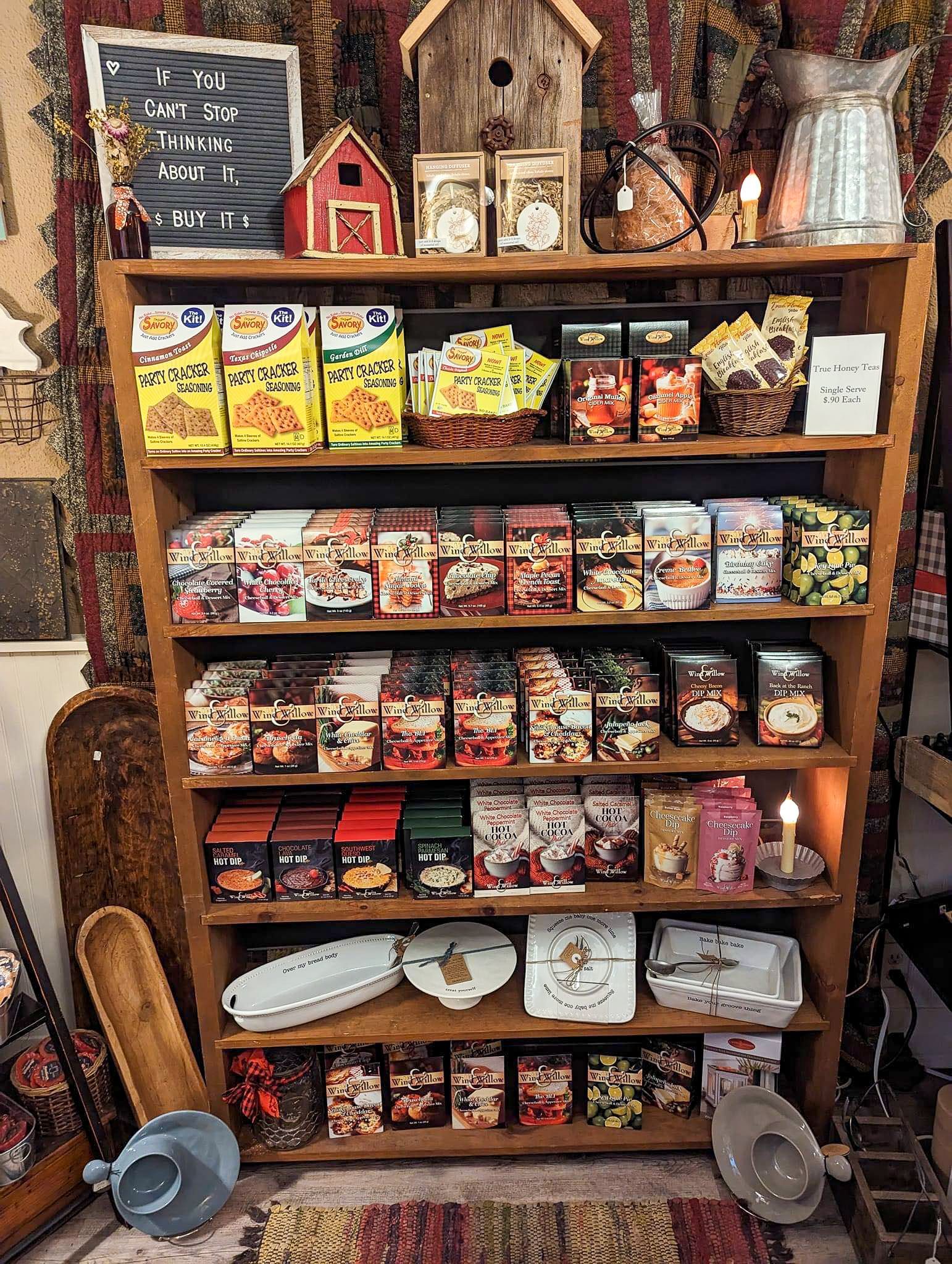 A wooden shelf filled with lots of food and candles.