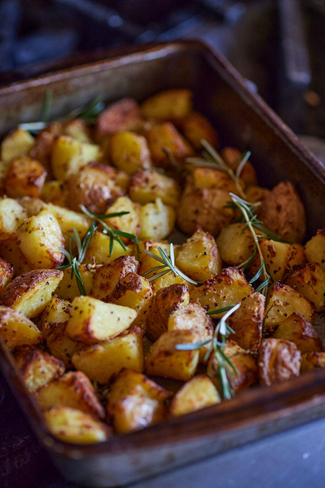 Roasted potatoes in a baking pan with rosemary sprigs, golden brown and crispy. Mariposa Sedona
