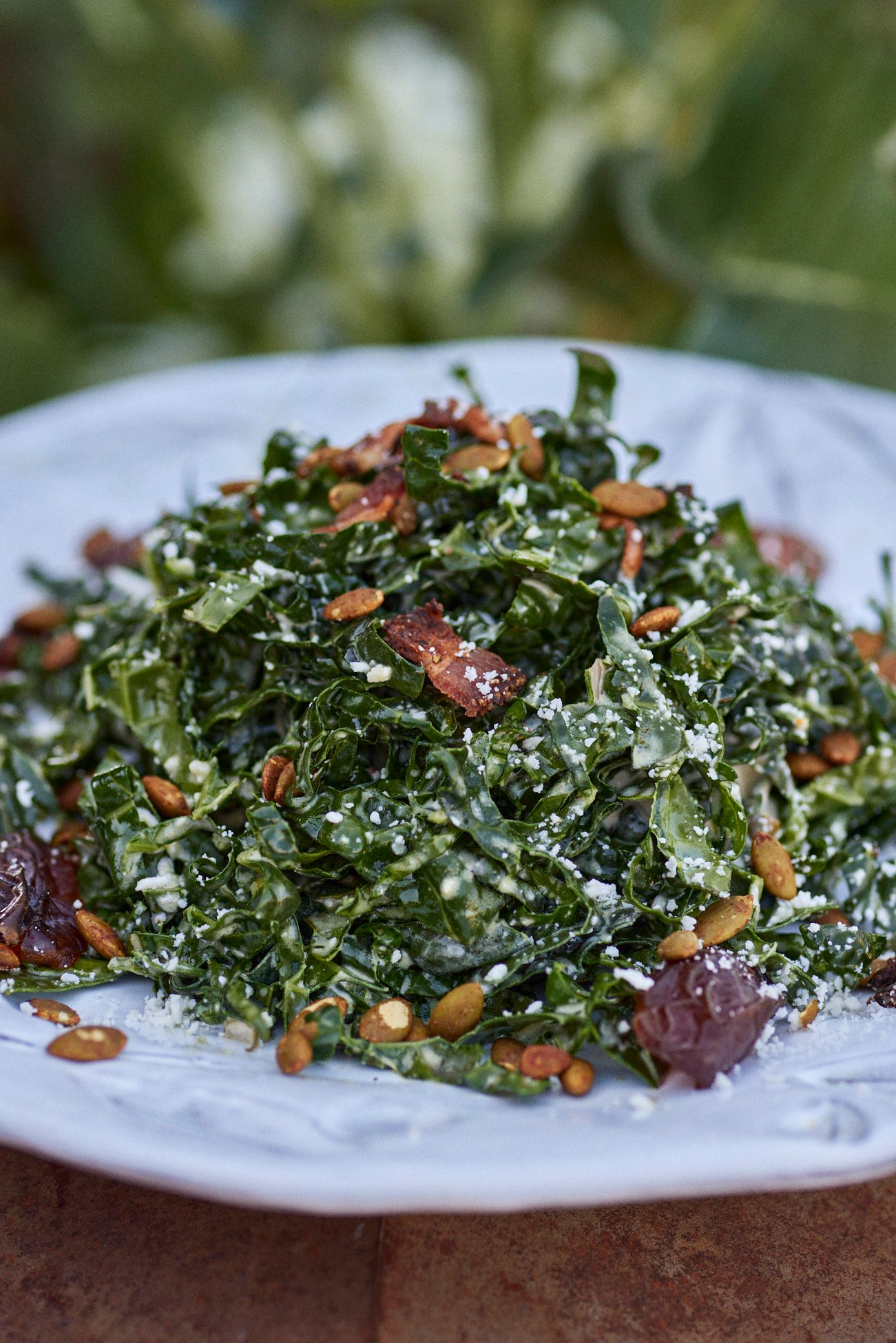 Kale salad with dates, almonds, and seeds on a white plate. Mariposa Sedona