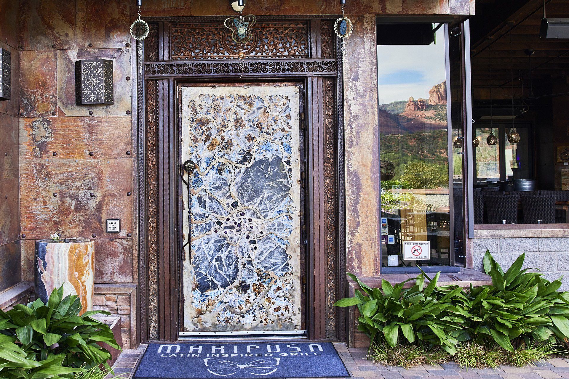 Rustic entrance with a metal door and frame, a welcome mat, and a window with a mountain view.