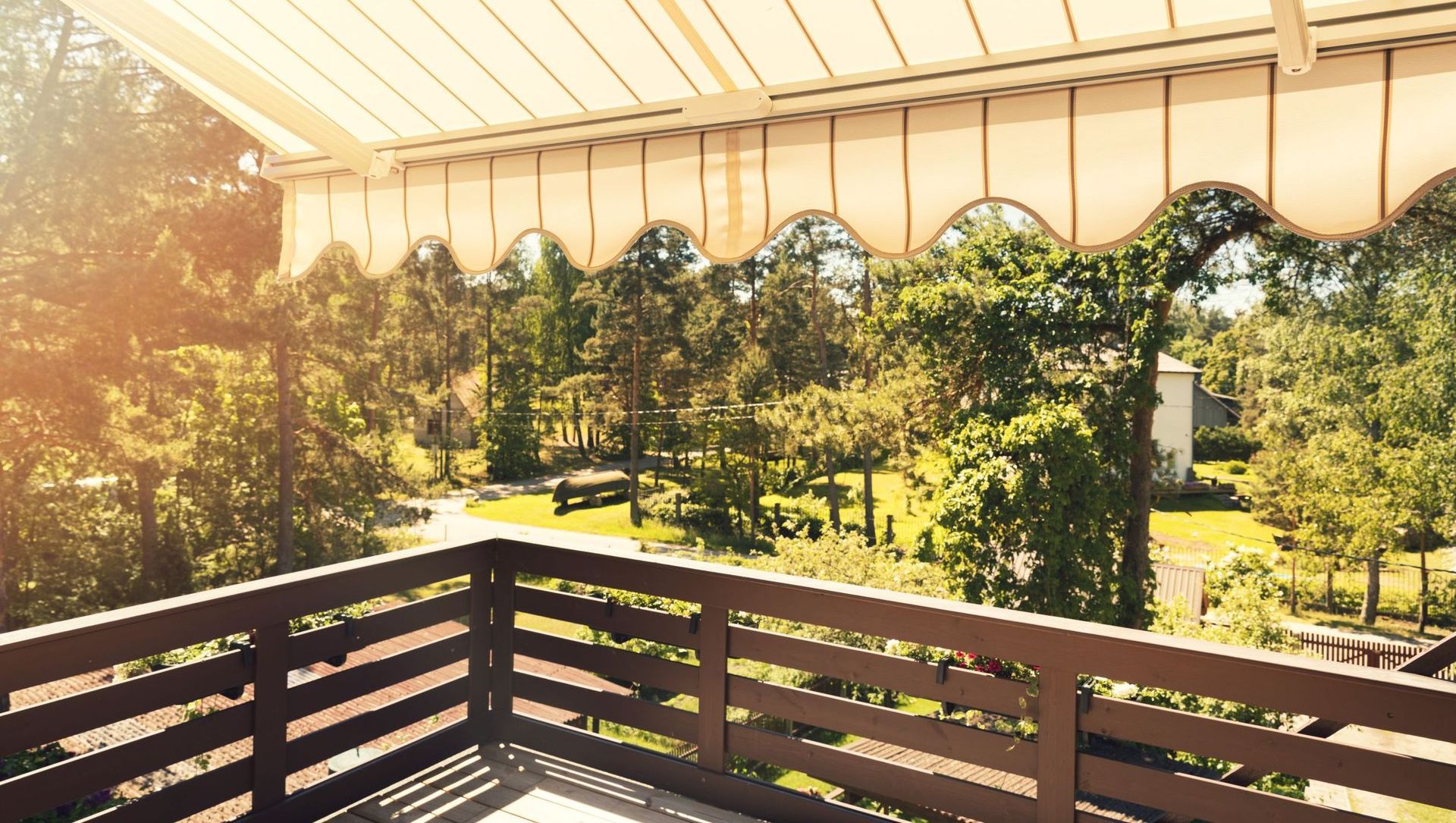 A balcony with a canopy over it and trees in the background