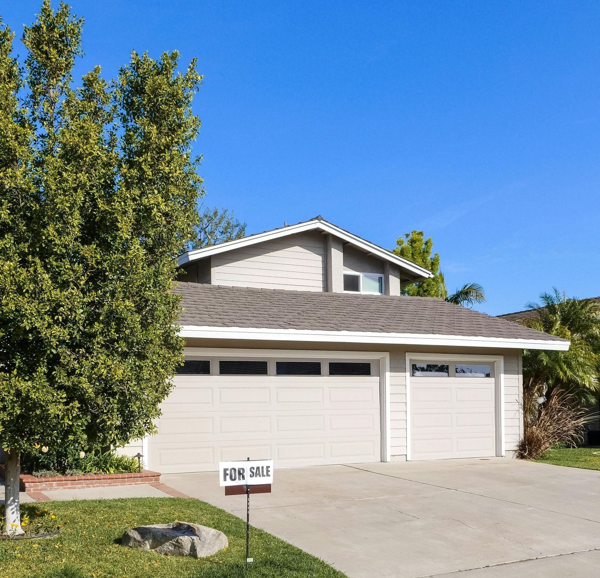A house with a for sale sign in front of it