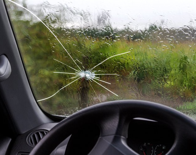 A car with a broken windshield and a steering wheel