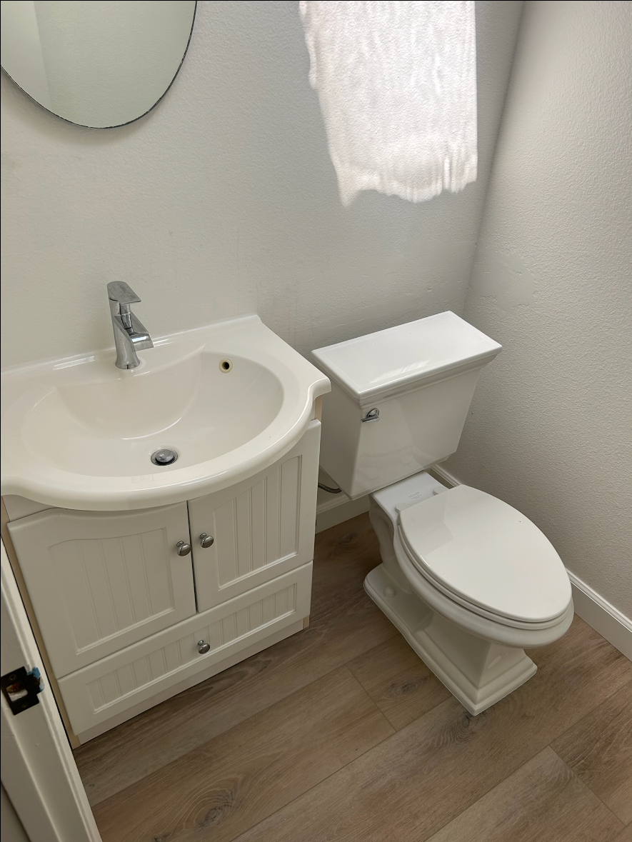 A bathroom with a sink , toilet and mirror.
