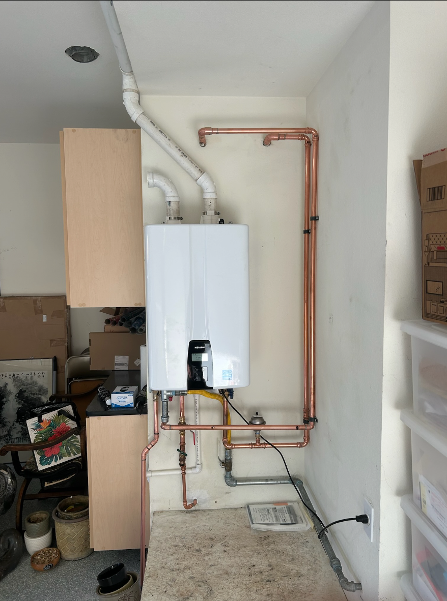 A white water heater is installed in a room with copper pipes.