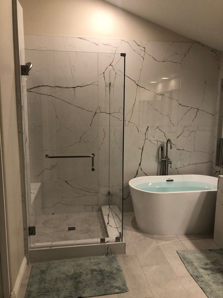 A bathroom with a bathtub and a walk in shower.