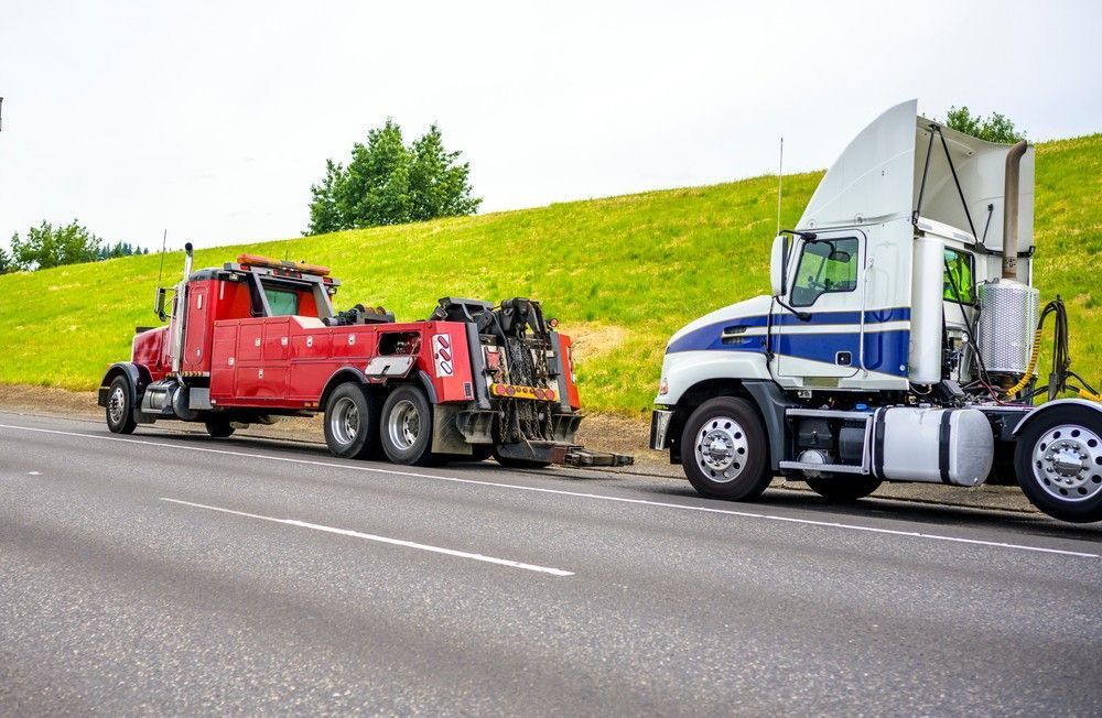 A Red Tow Truck Towing and Semi Truck on A Road — A1 Towing in Newcastle, NSW