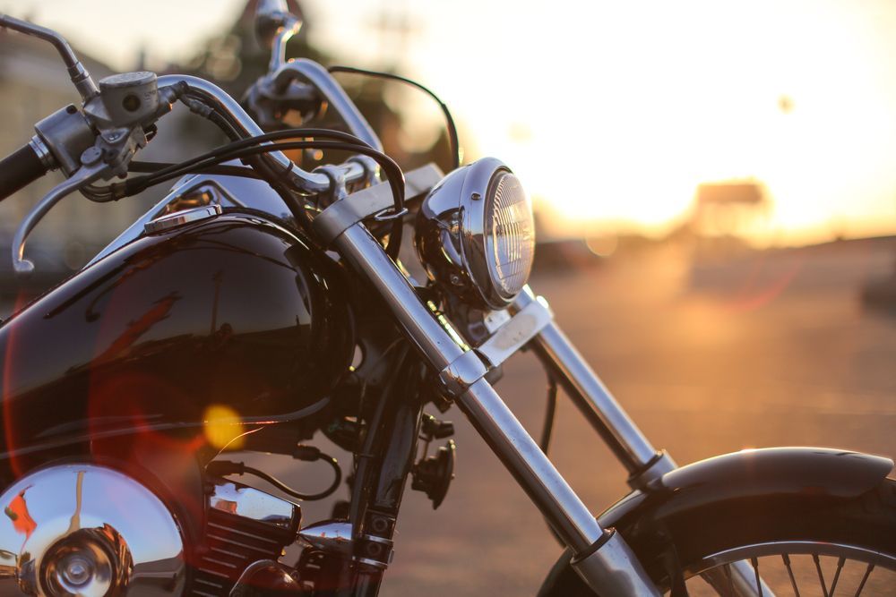 Black motorcycle with chrome details, parked outdoors at sunset.— A1 Towing in Blue Haven, NSW