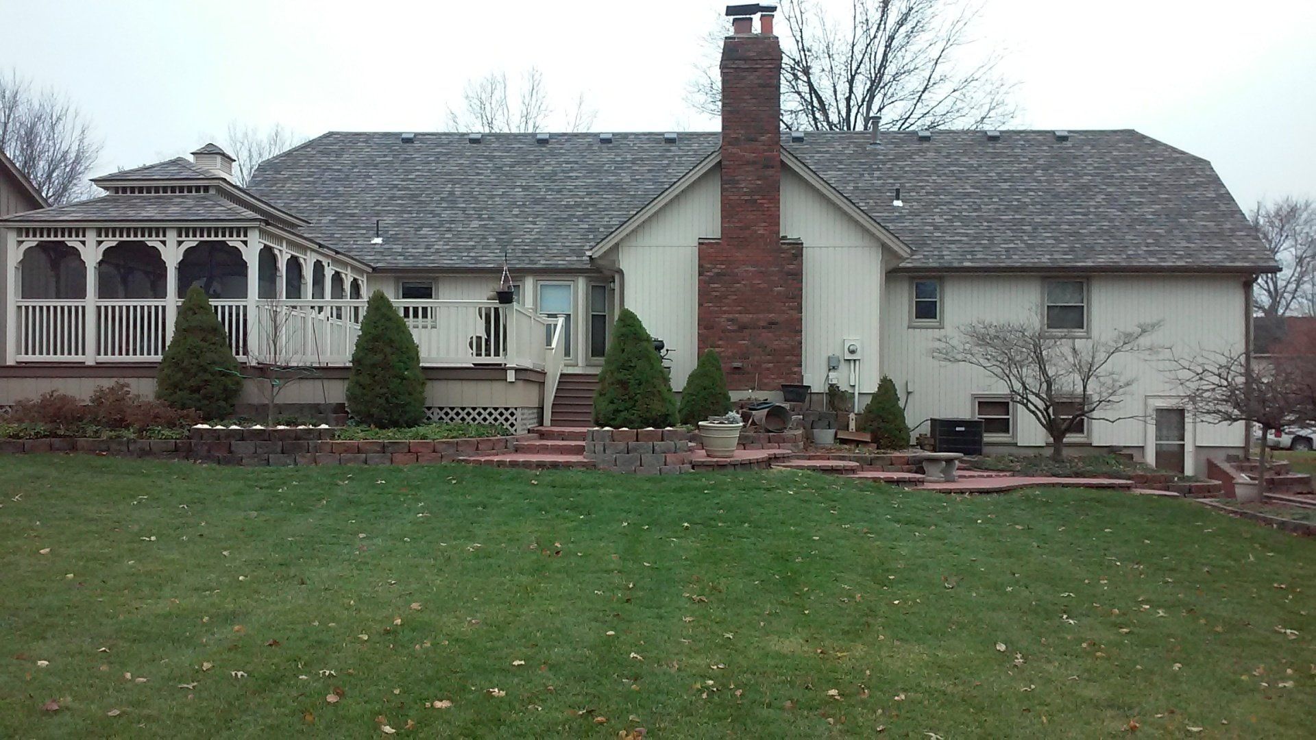 A large white house with a brick chimney and a gazebo